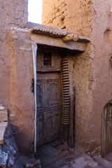 Fototapeta na wymiar Old wooden door, entrance to a building in the Kasbah Ait Ben Haddou near Ouarzazate in the Atlas Mountains of Morocco.