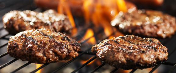 hamuburgers cooking on grill outdoors in panoramic composition - obrazy, fototapety, plakaty