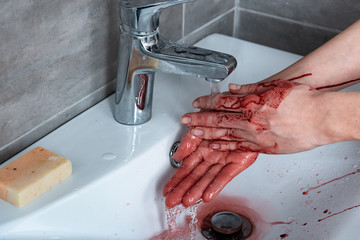 partial view of woman washing bleeding hands in bathroom