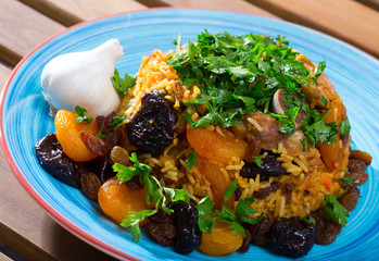 Lamb pilau with dried fruits and greens