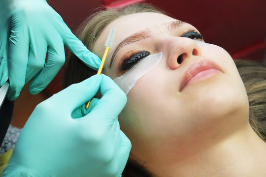 Beautiful Asian woman with long eyelashes in a beauty salon during eyelash extension. Eyelash extension procedure. Eyelashes close up.