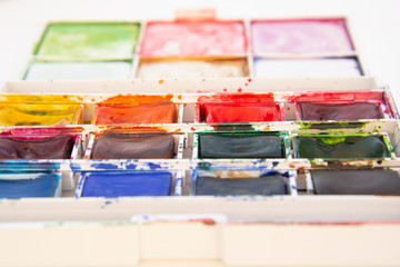 Set of watercolor paints isolated for painting closeup. Selective focus. Art, creative background with copy space.