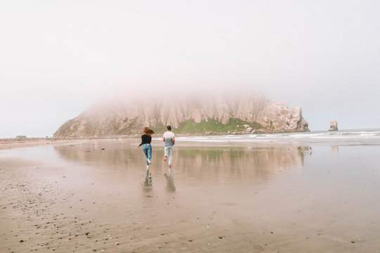 man and woman running on seashore