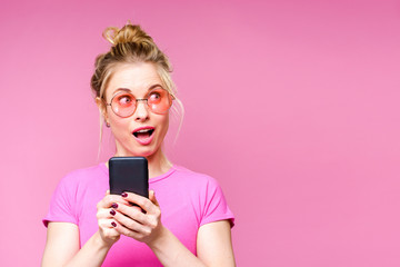 Image of blonde in pink T-shirt with phone in her hands