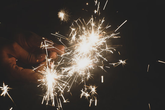 person holding lit sparklers