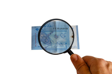 one Malaysia Ringgit and magnifying glass in hand isolated on white background, reverse side