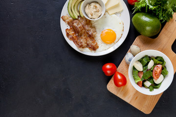 Ketogenic product: bacon, eggs, avocado, tomatoes, cream cheese, fresh salad. Healthy fats diet.