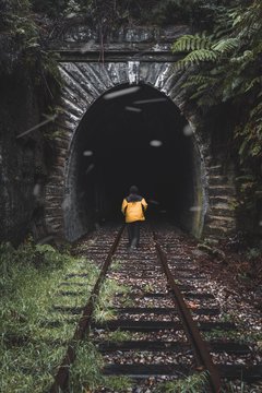 person stand in front of train cave