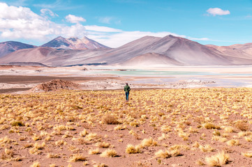 person standing on open field facing mountain during daytime