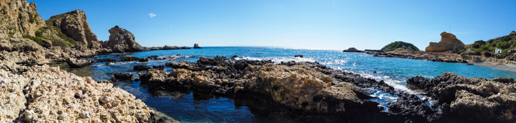 Fototapeta na wymiar beautiful stony coast of mediterranean sea in greece in sunny day. Wideangle