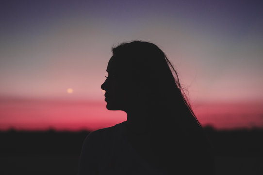 silhouette of woman sideview with red and orange sky