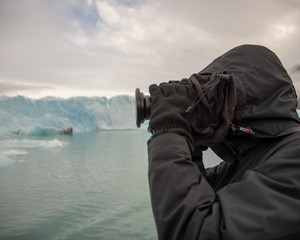 View of Glacier in Los Glaciares National Park in Argentina with person in foreground taking photos with a SLR camera 