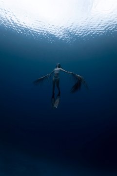 underwater photography of person with arms wide open
