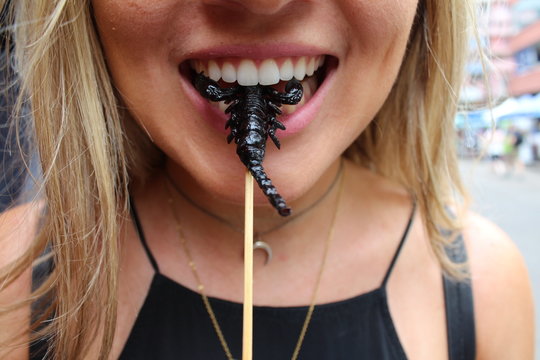 Woman Eating Scorpion On Stick