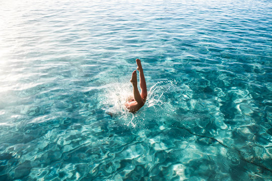woman diving on body of water
