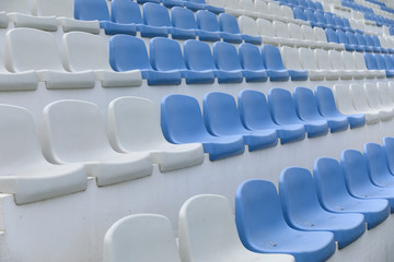 Empty stadium seats close up. Stadium chairs. Row after row of blue and white stadium seats.