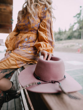 woman sitting while holding brown hat