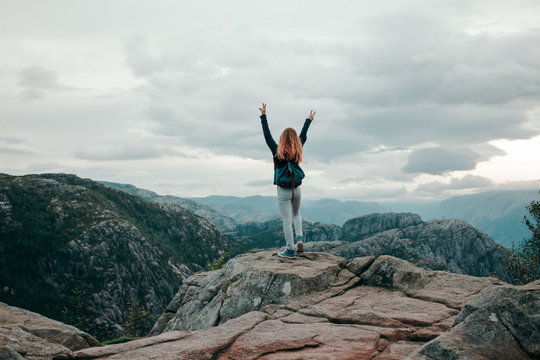 woman standing near mountain cliff
