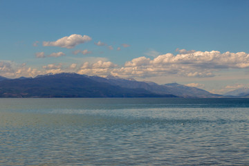 Landscape of Ohrid Lake. Looking at the mountain hills on the horizon, under the beautiful cloudy sky.