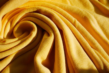 Yellow bright wool clothing wave backdrop surface.