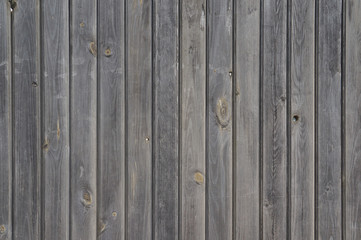 Fototapeta premium Vertically arranged gray shabby wooden planks. Old unpainted wooden wall - texture or background