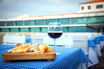 Assorted cheese and red wine on wooden platter