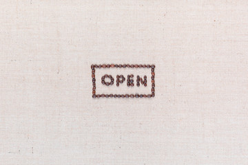The word Open inside a rectangle written with coffee beans,aligned in the center.