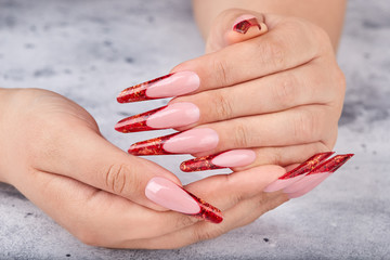 Hands with long red artificial french manicured nails 