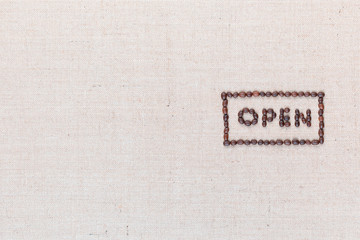 The word Open inside a rectangle written with coffee beans,aligned to the right.