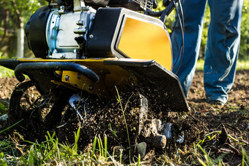 Grass and plowed soil nuggets during motor cultivator farm season work