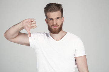 Portrait of a beautiful sexy bearded man. Shows a finger down. disapproves he stands in front of the white background