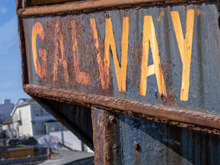 Old worn out sign: Galway. on a rusty metal surface. copy space.
