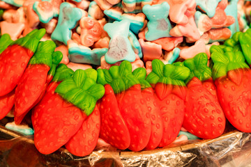 Multicolored gummies in the form of strawberries. Background Texture