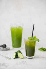 Refreshing cucumber basil lemonade. Poured into a glass and carafe