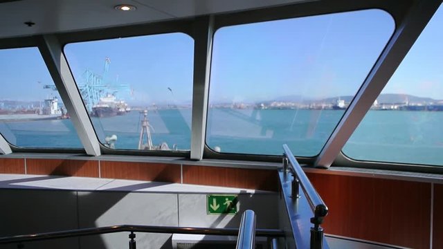 Algeciras, Spain view from inside ferryboat leaving Spanish goods and passenger port towards Ceuta with Gibraltar industrial cargo port and mountains on the horizon