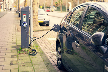Charging modern electric cars (new energy vehicles, NEV) on the street station