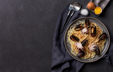 Free space pasta with seafood on dark background