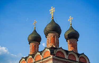 Fototapeta na wymiar Domes of an Orthodox church, blue sky with clouds.