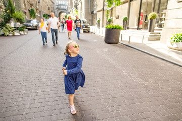 little girl in blue dress having fun outside