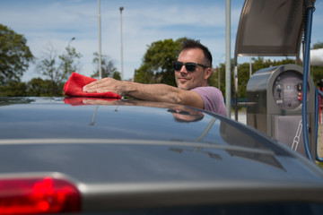 Naklejka premium Man cleaning his car outdoors