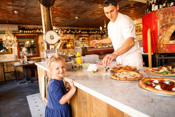 young family dad mom son and daughter eat tasty pizza in a restaurant