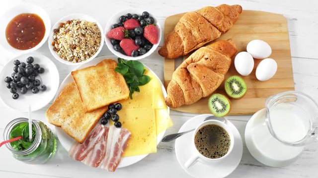 Top view female hand putting bakery croissant on serving table ready for breakfast POV shot