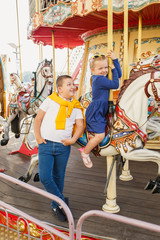 little children brother and sister having fun on the carousel
