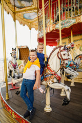 Fototapeta na wymiar little children brother and sister having fun on the carousel