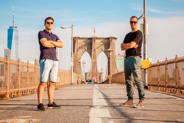 Tourist models posing for a photo on a Brooklyn Bridge