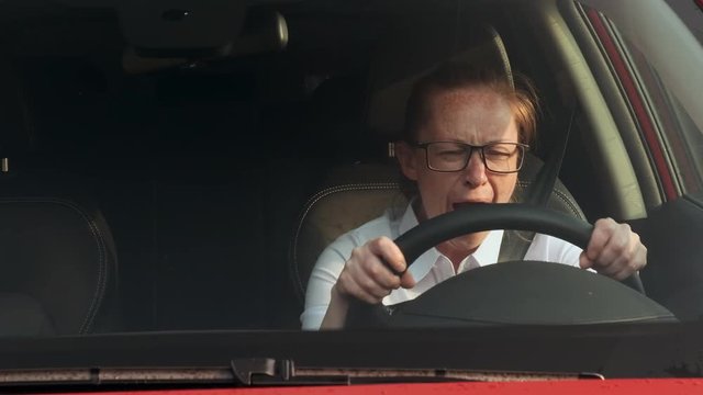 Sleepy girl driving a car. Tired woman is yawning traveling a auto.