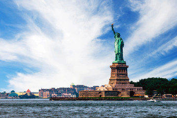 View of island of Liberty with statue of Liberty seen from the ferry in the Hudson river, symbol of the New York City, during sunny summer day