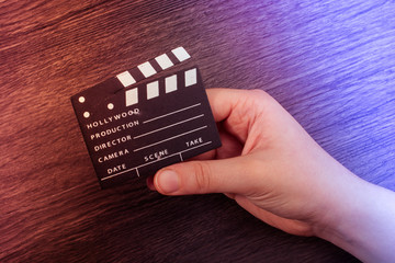 Hand holding a little movie  clapper in hand