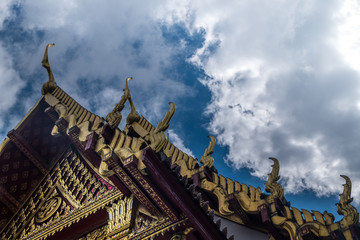 Fototapeta na wymiar The roof of the Thai temple, along with the gable at the top of the church with a sky backdrop