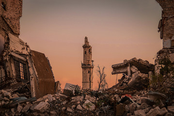 Destroyed buildings next to a mosque in the city of Aleppo in Syria - obrazy, fototapety, plakaty